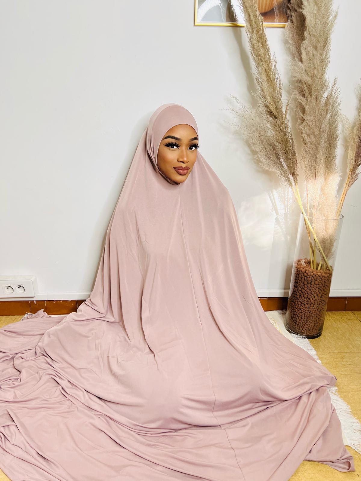 Femme musulmane en tenue de prière couvrant les cheveux, respectant la modestie religieuse.